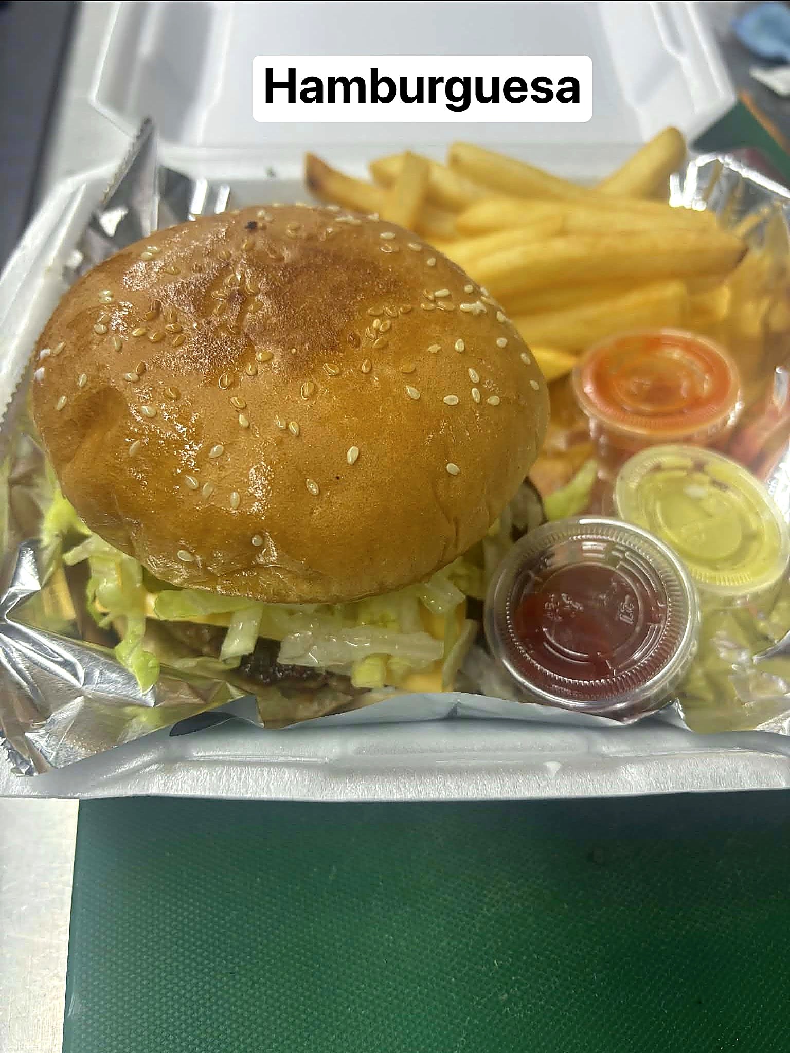 Hamburguesa with mayo, pickles, lettuce, tomato, cheese, meat, and fries