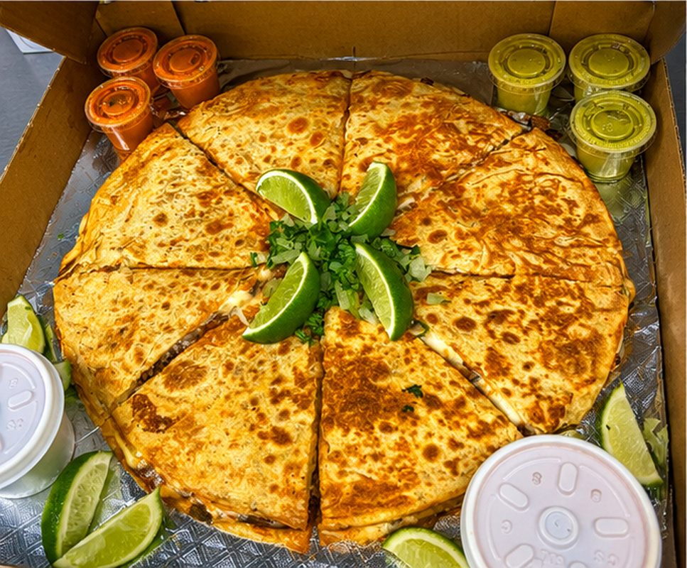 Pizza birria sliced like a pie with green salsa and lime